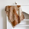 Vista detallada de la bufanda tipo patchwork con estampado de leopardo y flecos - Caqui