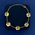 Japanese style gold bracelet with five yellow cushion-cut crystals on blue pad - Gold Tone + Clear White