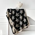 Dettaglio della sciarpa in maglia con stelle leopardate e morbida trama in cashmere - Nero