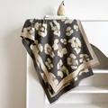 Grey and beige leopard print cashmere-like scarf with fringe on a white ladder display - Gray