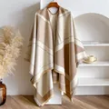 Detailed close-up of geometric V-pattern pashmina shawl with fringe trim on wooden hanger - Khaki