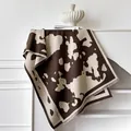 Kasjmier-achtige sjaal met bruine koeienprint en franjes op een decoratief display - 185x65cm / Donkerbruin