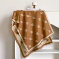 Detail view of brown knit scarf with daisy pattern, grid lines and soft fringe edge - 200x65cm / Khaki