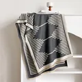 Modern cashmere-like shawl with gray geometric patterns and tassel details on a white shelf - 185x65cm / Gray