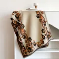 Detailed view of bohemian floral paisley patterns and tassel edges on a warm beige shawl - 185x65cm / Beige Orange