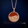Macro detail of rose gold Leo zodiac pendant with relief lion and semi-precious stone - Leo