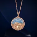 Detailed close-up of rose gold zodiac coin pendant with blue semi-precious stone inlay - Cancer