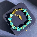 Detailopname van groene aventurijn kralen met gouden afstandhouders en driehoekige hanger - Turkoois Armband