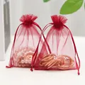 Red organza drawstring gift bag with semi-transparent texture and jewelry inside - Burgundy