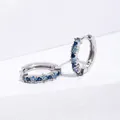 Macro detail of silver hoop earrings with gradient blue zircon and square gemstones - Silver+Blue Zirconia