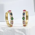 Macro shot of gold hoop earrings with multi-colored square and round cubic zirconia stones - Gold + Multi-color