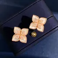 Dettaglio macro di orecchini a fiore a quattro petali con madreperla e zirconi - Oro Rosa Madreperla