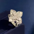 Luxe rhombic four-leaf clover flower ring with pavé diamonds on a blue velvet background - Silver Guilloché Style
