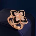 Close-up of rose gold four-petal flower ring with black enamel and pavé diamonds - Rose Gold Black Agate Style