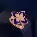 Macro detail of rose gold flower ring with blue inlay and sparkling pavé stones - Rose Gold Lapis Style