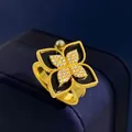 Vintage golden four-leaf clover ring with black stone and pavé zircon center on blue box - Gold Black Agate Style
