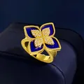 Macro detail of gold flower ring featuring blue enamel and sparkling diamond petals - Gold Lapis Style