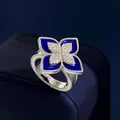 Macro view of a silver ring with blue enamel flower petals and shimmering diamond accents - Silver Lapis Style