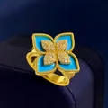 Macro shot of gold four-petal flower ring with turquoise and pavé diamond details - Gold Blue Turquoise Style