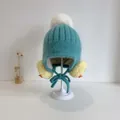 Gebreide baby wintermuts in blauw met witte pompon en schattig geel vogelontwerp - 48-50cm / Grasgroen