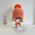 Baby Strickmütze mit Bommel und Ohrenklappen aus Kunstfell in warmem Korallrosa - 48-50cm / Karamellbraun