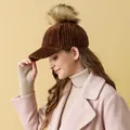 Detalle de una gorra de béisbol de pana marrón con un gran pompón de piel sintética - Ajustable / café
