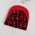 Red knit beanie with black 'ALL I NEED IS MONEY' text in a trendy streetwear style - Red
