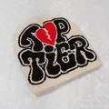 Detail of Y2K beige knit beanie with black TOP TIER text and a red broken heart pattern - Off White