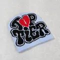 Close-up of light blue Y2K beanie with Top Tier lettering and a red broken heart graphic - Light Blue