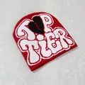 Detail of red knit beanie featuring white Top Tier text and black broken heart pattern - Burgundy