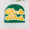 Detailed knit texture of green winter beanie featuring yellow Rich Mob embroidery - Green