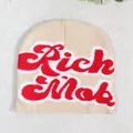 Beige knit beanie hat featuring bold red Rich Mob cursive embroidery and white outline - Off White