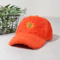 Détail de la casquette de baseball en peluche orange avec broderie soleil jaune et texture - Rouge Orangé