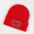 Red knit beanie featuring a sparkling rhinestone butterfly pattern on the folded cuff - Red