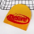 Detailed knit texture of bright yellow beanie with red Desire lettering embroidery - Orange