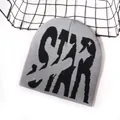 Graue Strickmütze mit schwarzem STAR-Jacquard-Schriftzug auf weißem Hintergrund - Einheitsgröße / Grau