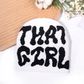 Bonnet en tricot blanc avec inscription THAT GIRL noire sur fond décoratif en bois - Taille unique / Blanc