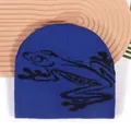 Dark blue knitted beanie with black frog pattern on a textured wooden tray background - One Size / Sapphire Blue