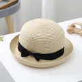 Detailed view of kids' straw hat with fine weave, round dome, and black ribbon bow - S (52-54cm) / Beige
