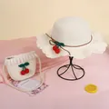Detail of kids straw hat and bag set with red cherry accents and wavy lace edges - Cherry Hat / White