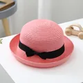 Pink woven straw sun hat for children with a black ribbon bow on white tabletop - S (52-54cm) / Dusty Pink