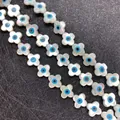 Macro detail of natural mother of pearl flower beads with blue evil eye inlay for DIY jewelry - Four-leaf Flower / Medium