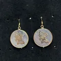 Rozenkwarts oorbellen met gouden koi vis patroon op een zwart displaybord - Koi Vis Stijl