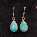 Water-drop imperial stone earrings with bronze bezel on a black velvet background - Blue