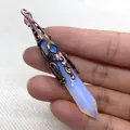 Vintage Hexagonal-Opal-Anhänger mit antiker Bronze-Filigrankappe in der Hand gehalten - Synthetischer Opal / Opal