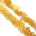 Macro detail of star-shaped yellow natural stone beads with smooth polished finish - 15x15x7mm / Topaz