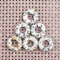 Detail van zes 20mm dalmatiër jaspis donut hangers op een gevlochten ondergrond - 20mm / Dalmatijnse jaspis