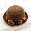 Detail of dark brown woven straw hat featuring delicate fabric floral decorations - Dark Coffee