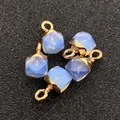 Detailansicht von fünf facettierten hellblauen Anhängern mit vergoldeter Legierungsöse - 6x11mm / Gold Opal