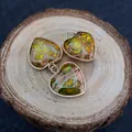 Dettaglio di tre ciondoli a cuore in turchese con bordo dorato su fondo in legno - 16x18mm / Stile Picchiettato Giallo Verde (N. 8)